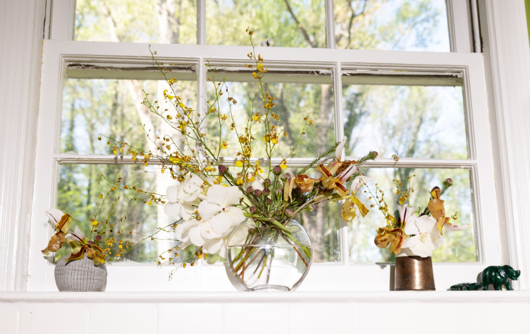 Trio of floral vignettes on a sunlit windowsill