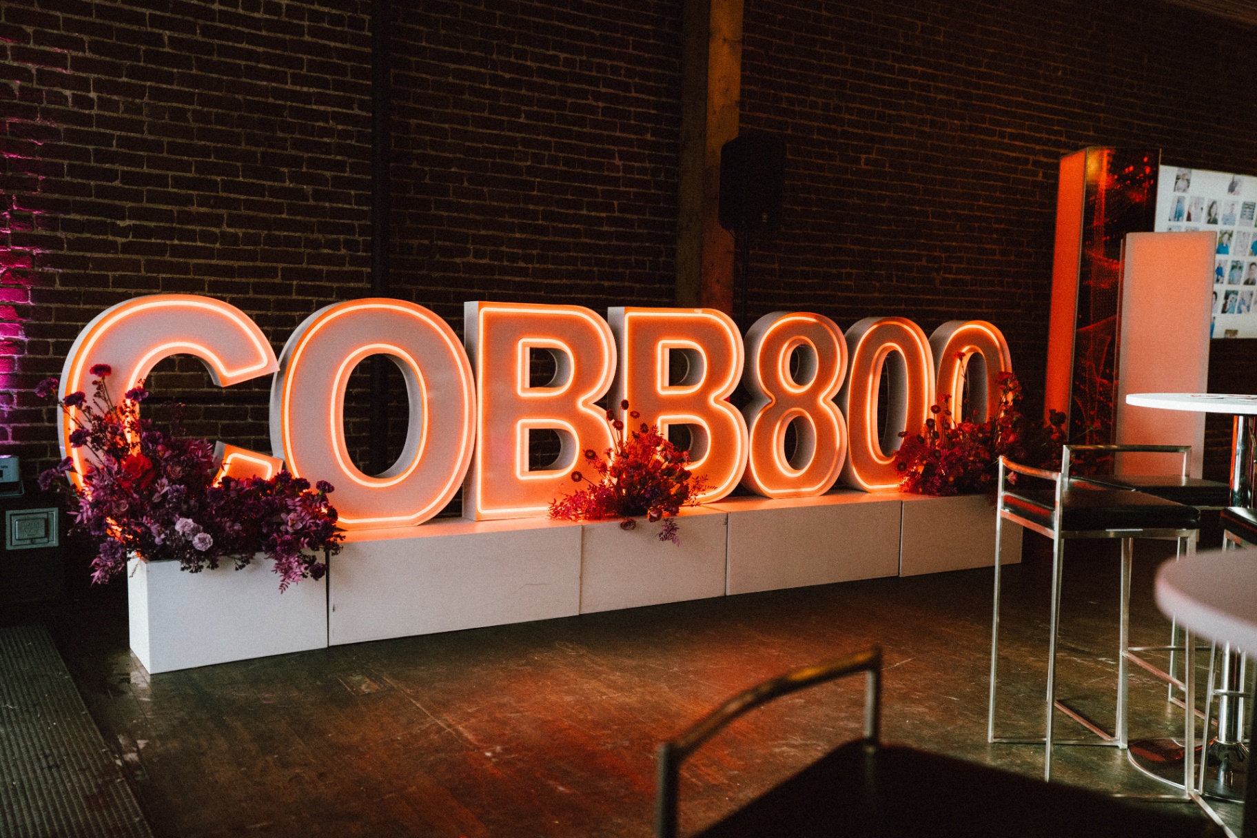 Glowing oversized COBB800 marquee letters skirted in mauve and crimson florals
