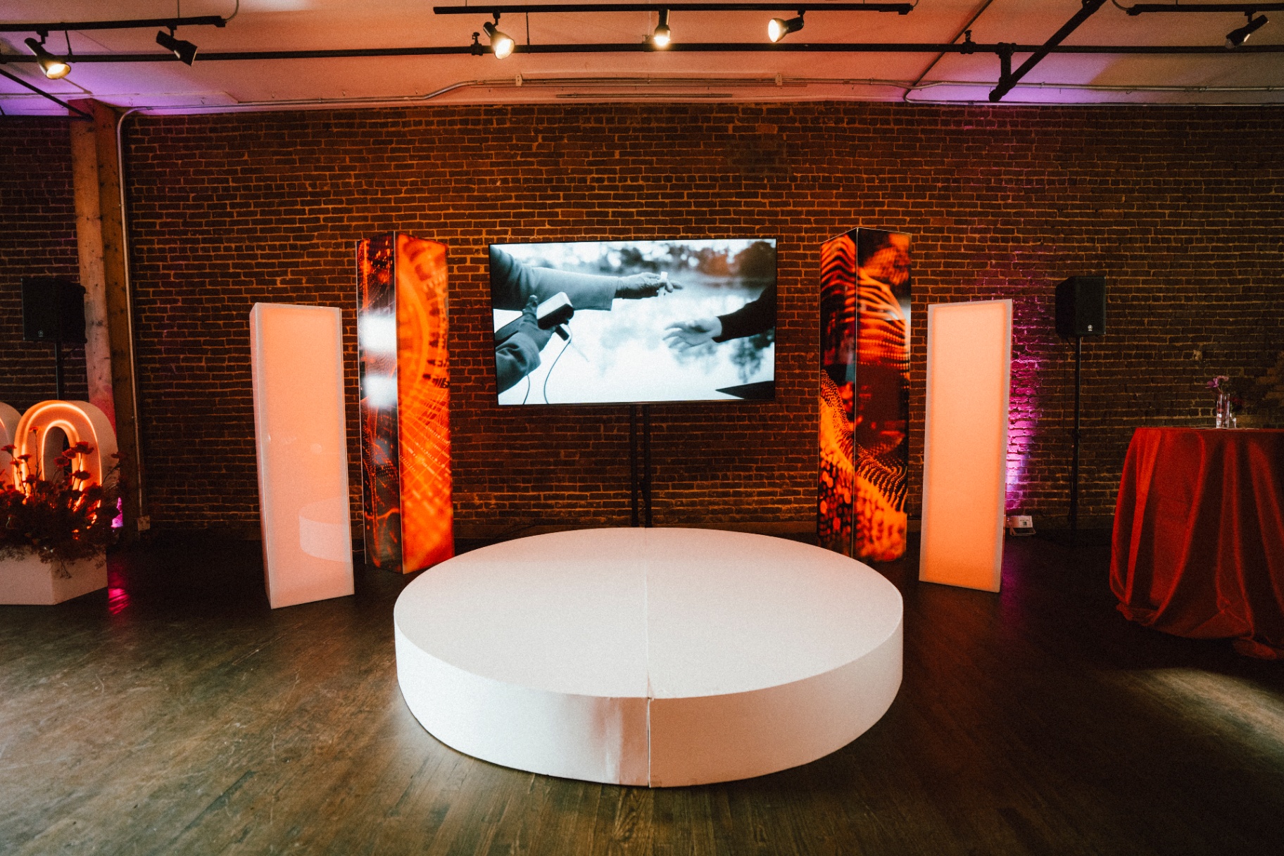 Illuminated white plinths and printed graphic panels staged against exposed brick